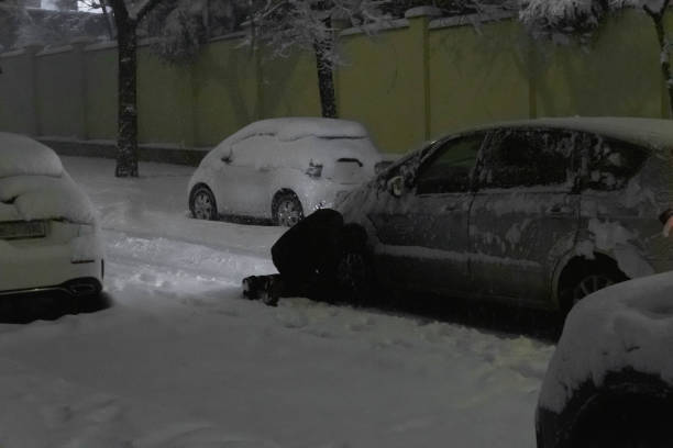 istock Man changing a car wheel in the snow during storm Philomena. 1456225043