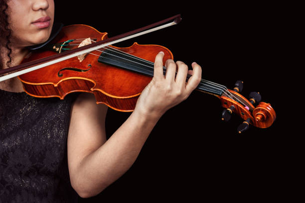istock Woman with violin in dark room. Copyspace. 1456226291