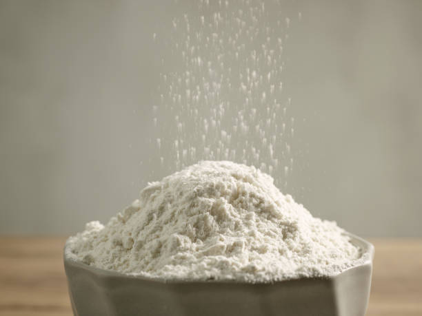 flour pouring into bowl stock photo