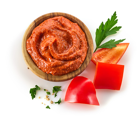 bowl of greek style tomato and red pepper dip sauce isolated on white background, top view