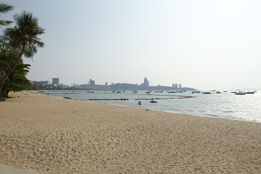 Panorama of Bay in Pattaya at beach. Many anchored boats in Pattaya in sea in front of harbor and beach in Pattaya north. In background is hill with Pattaya south and harbor