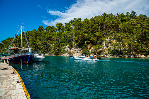 13 June 2022, Paxos, Greece , Sailing, fishing and pleasure boats are moored at the port of the island
