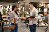 Woman handshaking a retail clerk while shopping at a furniture store
