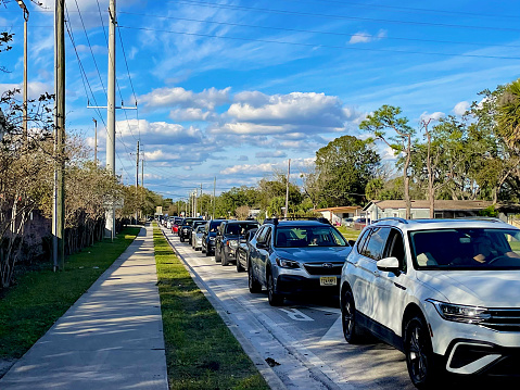 Sanford, Florida, USA - January 8, 2023: A mile-long line of vehicles waits to enter the Sanford Amtrak Auto Train Station following the late arrival of the Southbound Auto Train from earlier in the day.