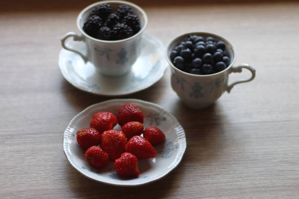 różne jagody w filiżankach vintage - berry fruit blueberry floral pattern strawberry zdjęcia i obrazy z banku zdjęć