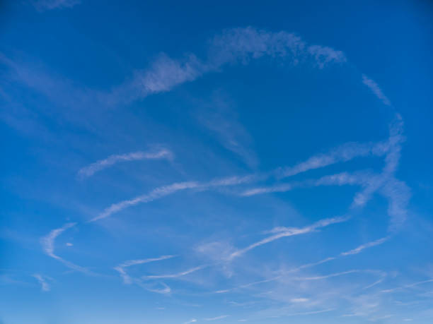 istock Bizarre white figures in blue sky painted by plane 1456233711
