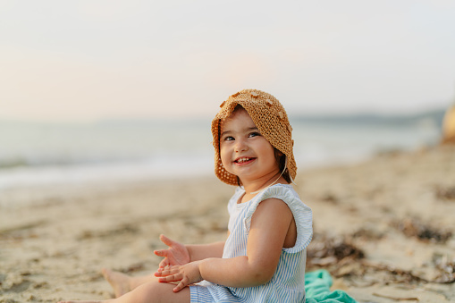 Photo of a little, two year old girl, playing in the sand during her summer vacation