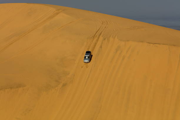 istock Car riding down the sand dune in the desert, Namibia 1456241828