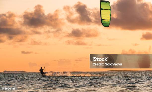 Sunset Sky Over The Indian Ocean Bay With A Kiteboarder Riding Kiteboard With A Green Bright Power Kite Active Sport People And Beauty In Nature Concept Image Le Morne Beach Mauritius Stock Photo - Download Image Now