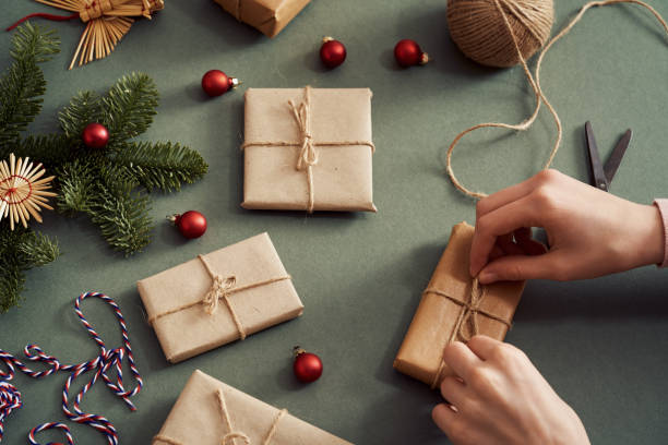 istock Hands wrapping Christmas presents in ecological recycled paper - zero-waste concept 1456246883