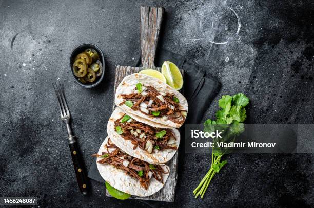 Pork Carnitas Tacos On Corn Tortillas With Onion And Lime Black Background Top View Stock Photo - Download Image Now