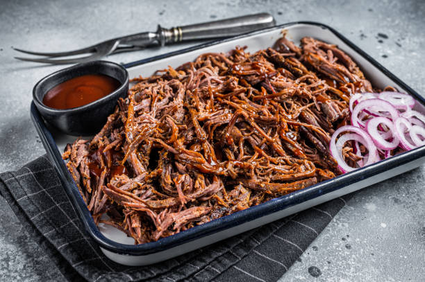 istock Pulled beef meat with hot chili sauce in baking dish. Gray background. Top view 1456248214