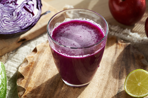 Fresh homemade purple cabbage juice with apple and lime