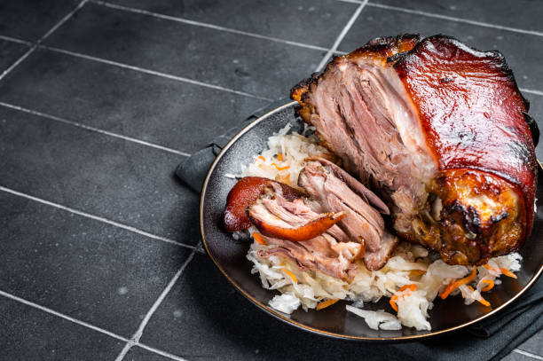 istock Roast Pork Ham Hock, knuckle with Sauerkraut on a plate. Black background. Top view. Copy space 1456249462