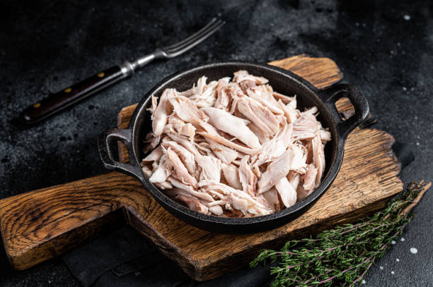 istock Sliced Pieces of chicken meat in a skillet, pulled chicken. Black background. Top view 1456250908