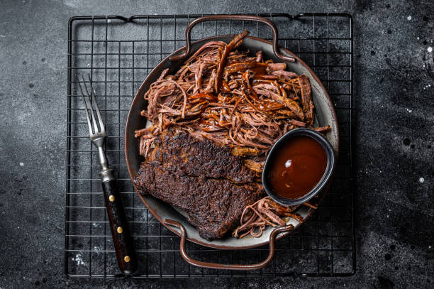 istock Slow Cooked Pulled Beef, Traditional meat rubbed with spices and smoked in a Texas smoker. Black background. Top view 1456251027