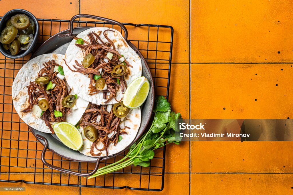 Spicy Beef Barbacoa Tacos with Cilantro and Onion. Orange background. Top view. Copy space Spicy Beef Barbacoa Tacos with Cilantro and Onion. Orange background. Top view. Copy space. Avocado Stock Photo