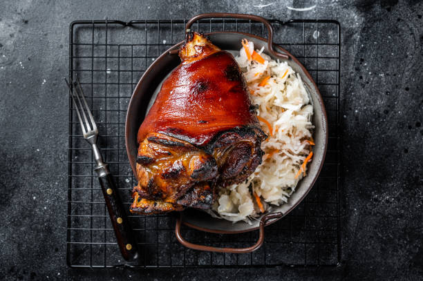 traditional german cuisine roasted pork knuckle schweinshaxe with sauerkraut. black background. top view - shank sauerkraut german cuisine pork imagens e fotografias de stock