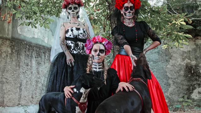 Slow motion Costume performance of three Women in the guise of Holy Death with dogs. Traditional Dia de Los Muertos Festival in Mexico