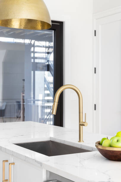 istock A gold kitchen faucet detail in a white kitchen. 1456256116