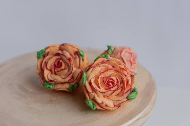 sobre un fondo redondo de madera se encuentran malvaviscos naranjas naturales en forma de flores de rosas. - orange rose candy valentines day fotografías e imágenes de stock