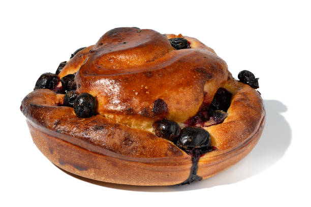 Baked round bun with cherry berries on a white isolated background