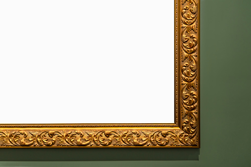Golden vintage frame isolated on green wall in museum.