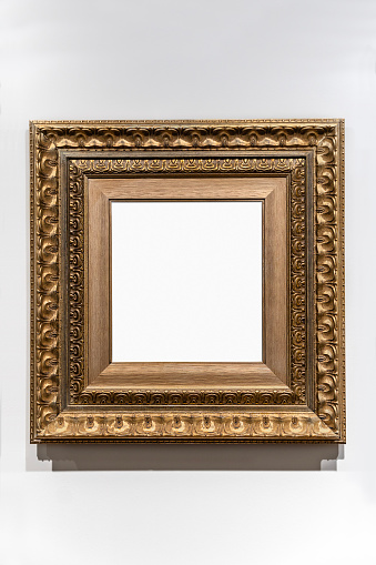 Golden vintage frame on white wall in museum.