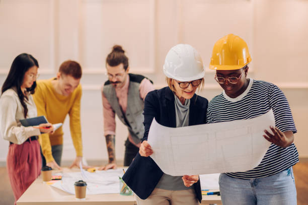 istock Portrait of two diverse architect looking at blueprints in an office 1456274820