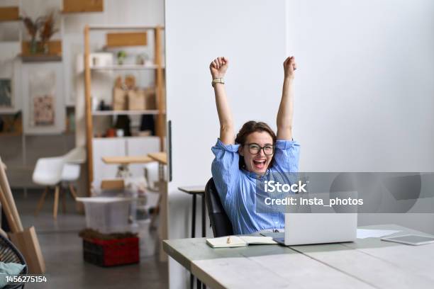 Happy Excited Young Woman Student Or Employee Using Laptop Celebrating Success Stock Photo - Download Image Now