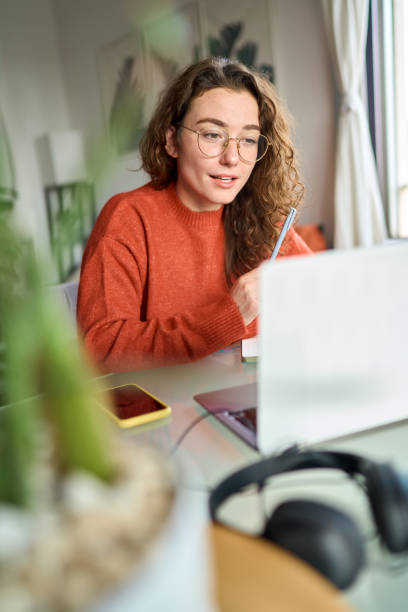 istock Young woman student elearning or having hybrid virtual meeting at home. 1456275182