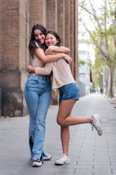 istock women smiling and hugging looking at camera 1456275829