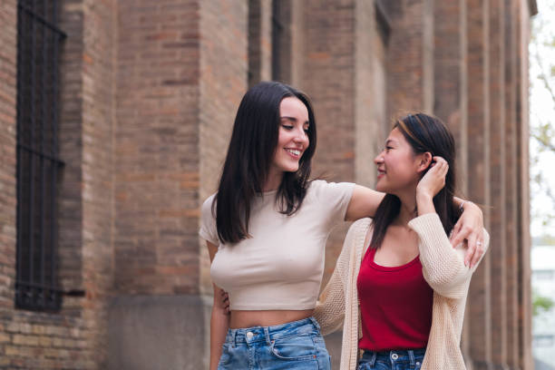 istock women smile in love as they stroll hugging 1456275831