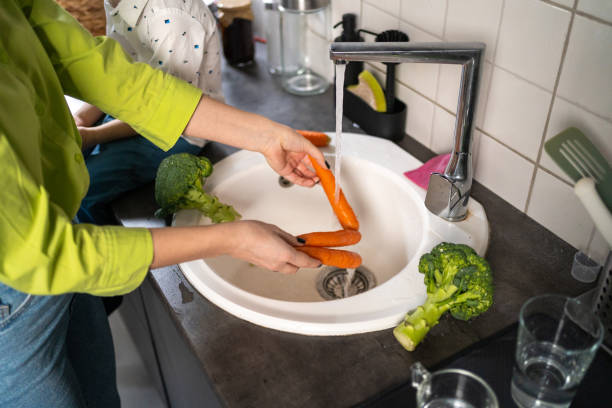 istock Mother  washing vegetables in kitchen 1456276848
