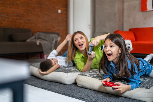Happy family playing video games in living room at home