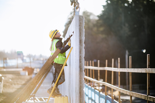 A female Caucasian laborer works on a large scale light-rail project in Washington state.  A well paying trade job for a needed skillset.