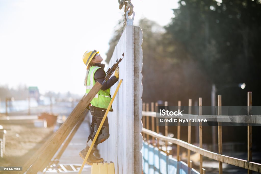 Woman Working In Construction Industry A female Caucasian laborer works on a large scale light-rail project in Washington state.  A well paying trade job for a needed skillset. Construction Site Stock Photo
