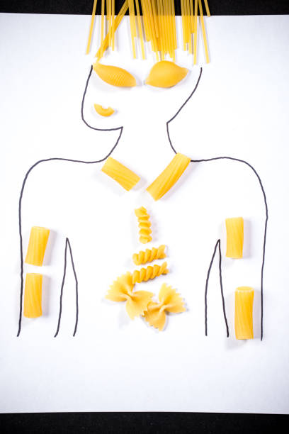 Young woman spinning spaghetti on hair curlers against green background. Unusual presentation of food. Restaurant menu. Concept of food pop art photography, creativity, quirky style