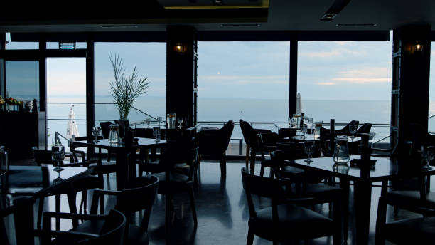 istock Dark interior in modern panoramic bar. Scenic ocean view in luxury lounge cafe 1456279364