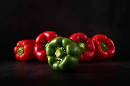 Directly above shot of fresh vegetables in red color on white table. Assortment of fresh and organic chillies, onion, rasdish, cherry tomatoes and red bell pepper on white background.