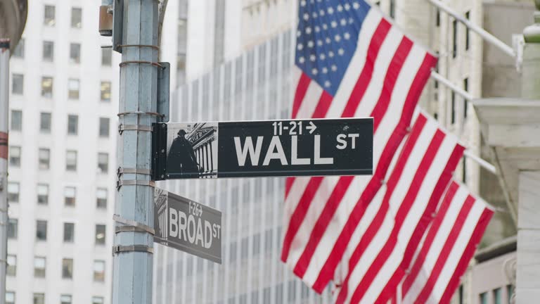 Wall street district in New York City with USA flags in the background