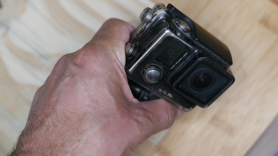 Man holds an old action camera.