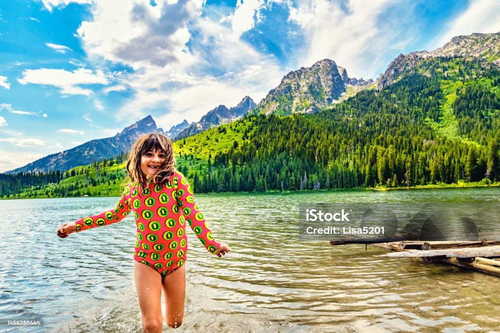 Joyful child plays on the banks of scenic String Lake in Grand Teton in summer String Lake Wyoming 6-7 Years Stock Photo