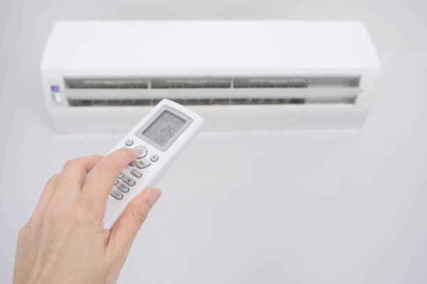 istock Man's hand using remote control open The air conditioner is cooled to 25 degrees Celsius in his bedroom. Health concepts and energy savings 1456291376