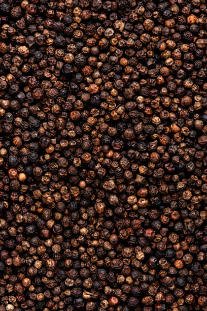 istock Black pepper, peppercorns, dry spice, food background texture, top view 1456295200