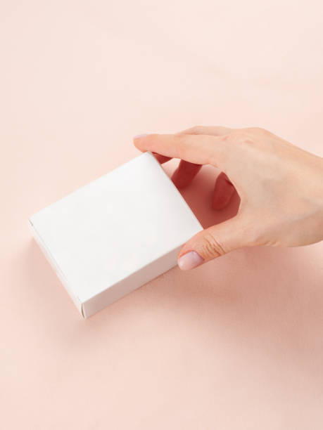 istock Blank White Product Package Box Mock-up. In a female hand. Container, Packaging Template on white .White cardboard box. 1456311568