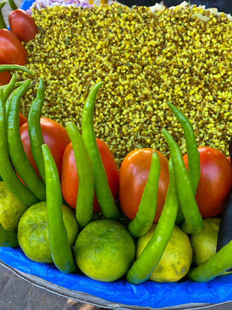 istock Full frame image of outdoor roadside market stall, stack of fruit and vegetables on table top, limes, green chilli peppers, tomatoes and bean sprouts, elevated view, focus on foreground 1456311613