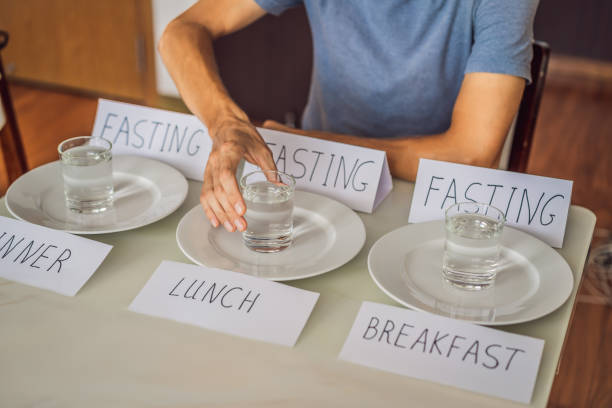 The man replaces his meals with water. Intermittent fasting concept, top view stock photo