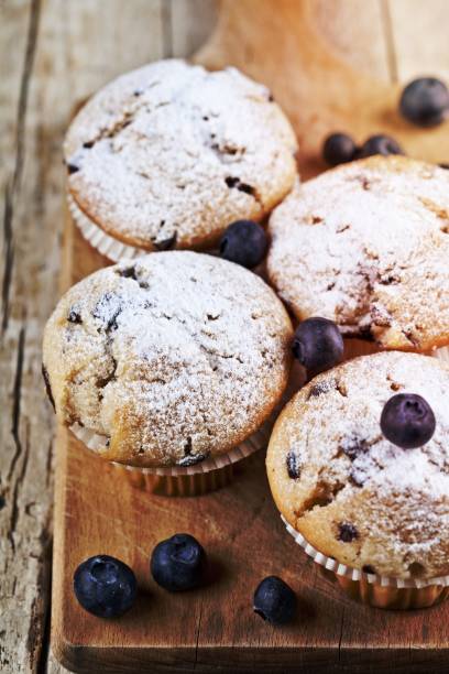 istock Four homemade fresh muffins with blueberries on rustic wooden table. 1456319046