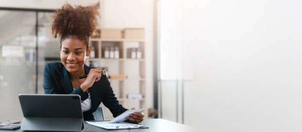 istock Young African American female working with tablet computer on remote project watching webinar. doing corporate data digital technology analysis. 1456322132
